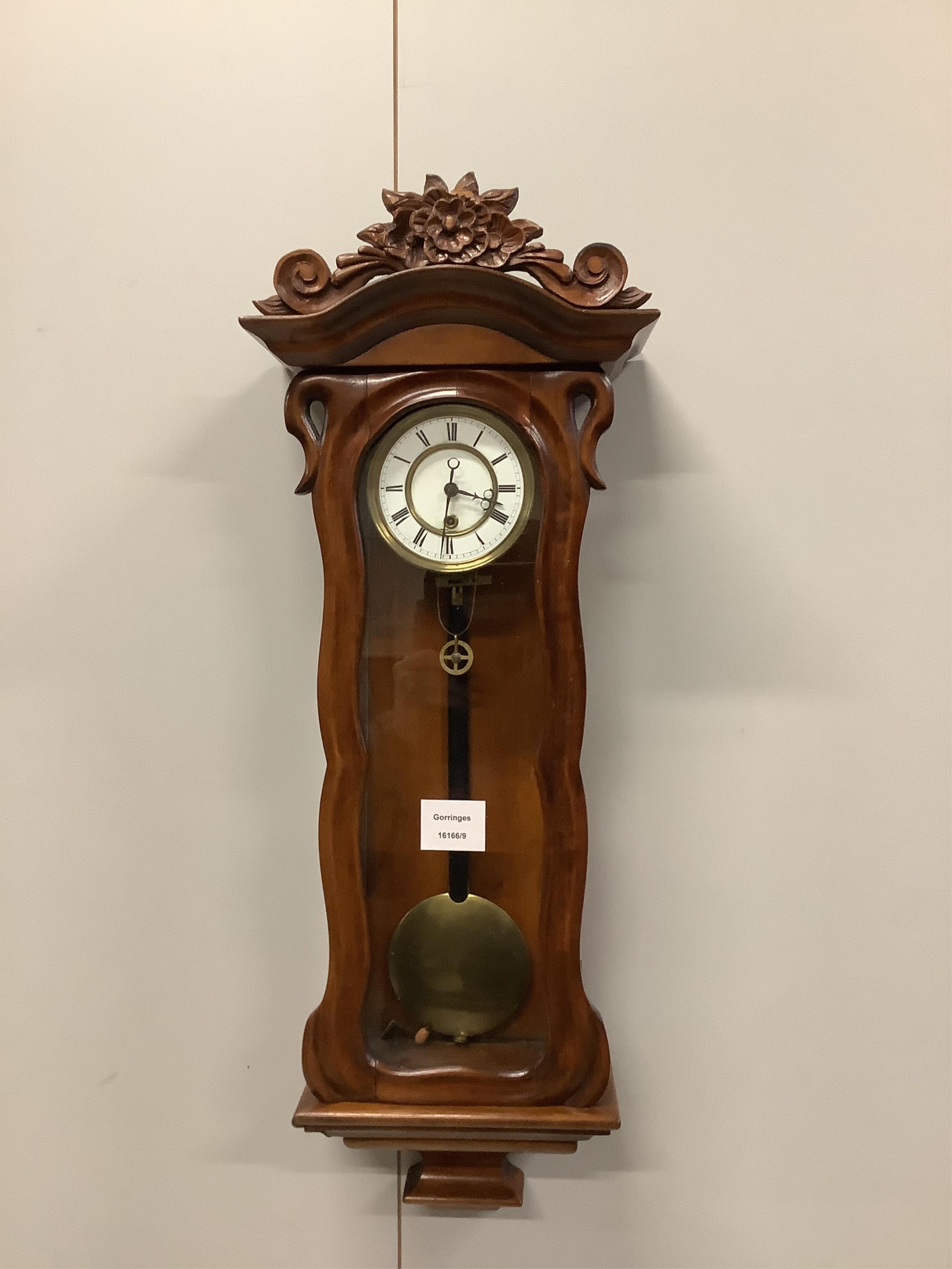 A small late 19th century carved glazed mahogany eight day Vienna style wall clock, height 64cm. Condition - good